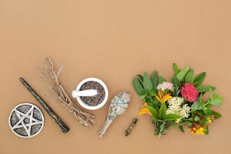 Ayurvedic herbs, oils and a stone mortar arranged on a wooden table